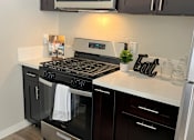 Thumbnail 37 of 45 - a kitchen with a stove and a microwave
