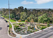 Thumbnail 41 of 51 - A street view of a residential area with a roundabout and trees.
