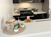 Thumbnail 36 of 45 - a kitchen with black cabinets and a counter top