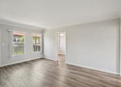 Thumbnail 21 of 51 - A room with wooden floors and white walls.