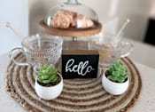 Thumbnail 45 of 45 - a table with a plate with a sign and plants on it
