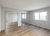 Thumbnail 11 of 11 - A room with wooden floors and white walls.