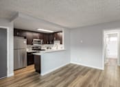 Thumbnail 8 of 11 - A kitchen with wooden floors and white walls.