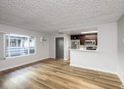 Thumbnail 7 of 11 - A spacious room with wooden flooring and a kitchenette.