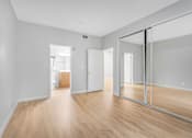 Thumbnail 13 of 30 - A room with wooden floors and white walls.
