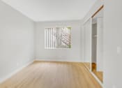 Thumbnail 20 of 30 - A room with wooden floors and a window with blinds.