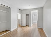 Thumbnail 8 of 30 - A white room with wood floors and a closet with a sliding door.
