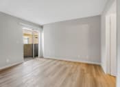 Thumbnail 16 of 35 - A room with wooden flooring and white walls.