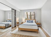 Thumbnail 4 of 30 - A bedroom with a large bed and a mirror on the wall.