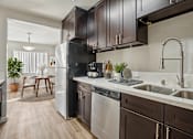 Thumbnail 3 of 48 - A modern kitchen with dark brown cabinets and stainless steel appliances.