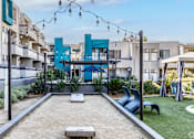 Thumbnail 9 of 54 - a courtyard with a pool and chairs and a blue building