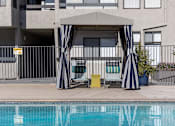 Thumbnail 33 of 54 - a pool cabana with two chairs next to a swimming pool