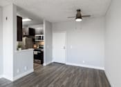 Thumbnail 43 of 54 - an empty living room with a ceiling fan and a kitchen