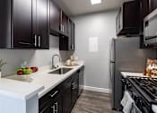 Thumbnail 2 of 54 - a kitchen with black cabinets and stainless steel appliances and a white counter top