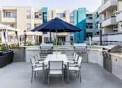 Thumbnail 7 of 54 - a patio with an umbrella and a table with chairs