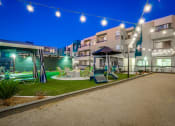 Thumbnail 50 of 54 - a courtyard with swings and lawn furniture at night