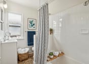 Thumbnail 5 of 40 - A bathroom with a white shower curtain and a white sink.