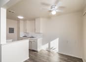 Thumbnail 24 of 37 - A white kitchen with a fan on the ceiling.