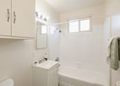 Thumbnail 30 of 37 - A white bathroom with a towel hanging on the rack.