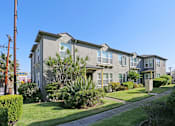 Thumbnail 11 of 47 - A row of houses with green plants in front.