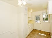 Thumbnail 21 of 47 - A kitchen with white cabinets and a ceiling fan.