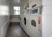 Thumbnail 36 of 47 - A laundry room with a washer and dryer.
