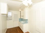 Thumbnail 45 of 47 - A kitchen with white cabinets and a blue backsplash.