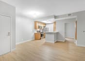 Thumbnail 15 of 30 - A kitchen with white walls and wooden floors.