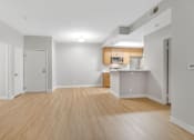 Thumbnail 11 of 30 - A spacious room with wooden flooring and white walls.