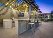 Thumbnail 46 of 54 - a patio with a bar and tables with chairs