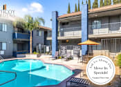 Thumbnail 33 of 37 - A pool surrounded by buildings with a sign that says "Ask Us About Our Move-In Specials!".