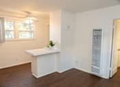 Thumbnail 10 of 30 - A white room with a window, a plant, and a white cabinet.