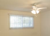 Thumbnail 22 of 31 - an empty living room with a ceiling fan and a window