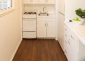 Thumbnail 24 of 31 - a small kitchen with white cabinets and a ceiling fan