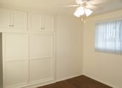 Thumbnail 23 of 31 - a bedroom with white walls and a ceiling fan
