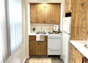 Thumbnail 9 of 31 - a small kitchen with white appliances and wooden cabinets