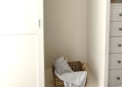 Thumbnail 25 of 31 - a closet with a basket of towels in it