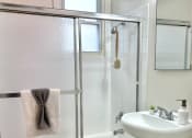 Thumbnail 10 of 31 - a white bathroom with a shower and a sink