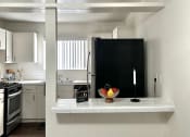Thumbnail 2 of 21 - a kitchen with a counter top and a refrigerator