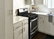 Thumbnail 1 of 31 - an empty kitchen with white cabinets and a black stove