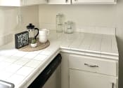 Thumbnail 5 of 31 - a small kitchen with white cabinets and a counter top and a sink