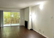Thumbnail 27 of 31 - an empty living room with wood floors and a sliding glass door