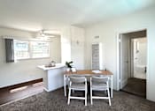Thumbnail 15 of 30 - A white room with a table and chairs.