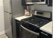 Thumbnail 20 of 54 - a kitchen with stainless steel appliances and black and white cabinets