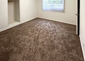 Thumbnail 17 of 30 - A room with a ceiling fan and carpeted floor.