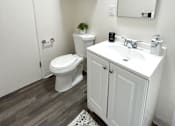 Thumbnail 7 of 30 - A white bathroom with a toilet, sink, and mirror.