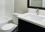 Thumbnail 16 of 40 - a bathroom with a toilet and a sink and a mirror
