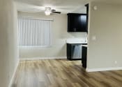 Thumbnail 9 of 40 - an empty living room and kitchen with wood flooring and a ceiling fan