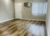 Thumbnail 13 of 40 - an empty living room with wood flooring and a window