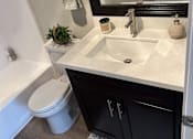 Thumbnail 32 of 45 - a bathroom with a toilet and a sink and a mirror
